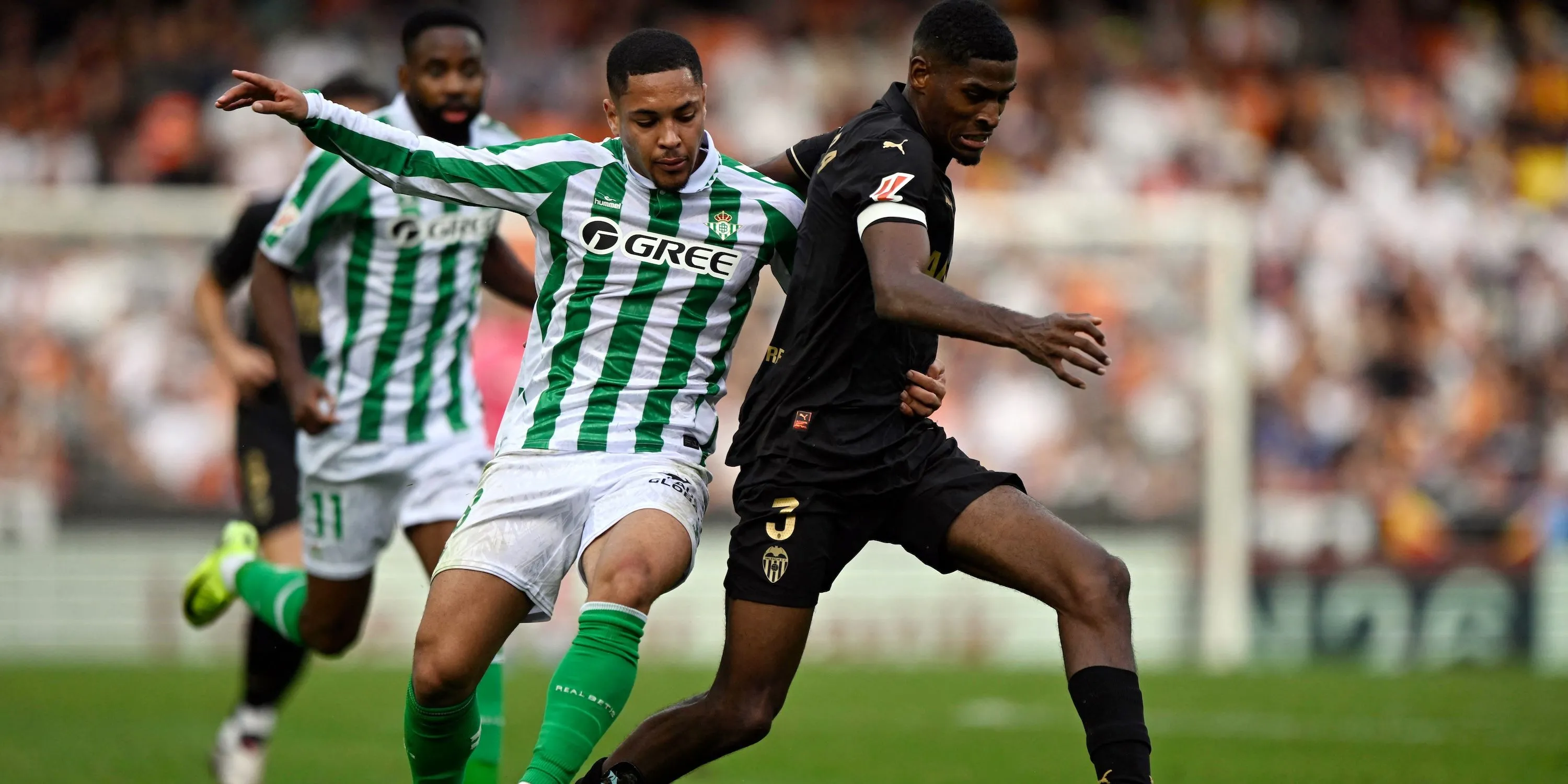 Trung vệ Cristhian Mosquera của Valencia tranh bóng với cầu thủ Real Betis