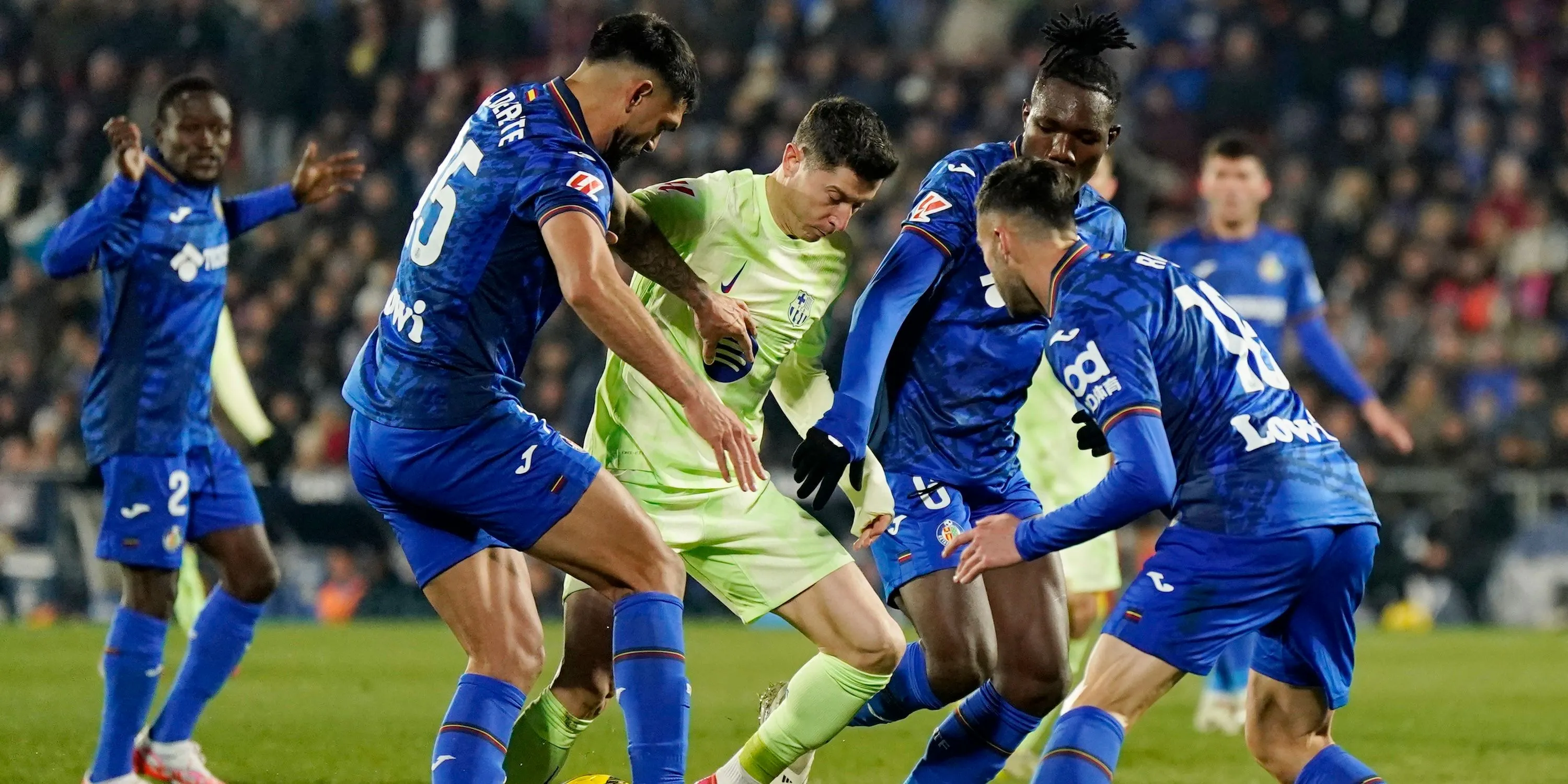 Christantus Uche của Getafe và Omar Alderete của Getafe trong trận đấu với Robert Lewandowski của FC Barcelona