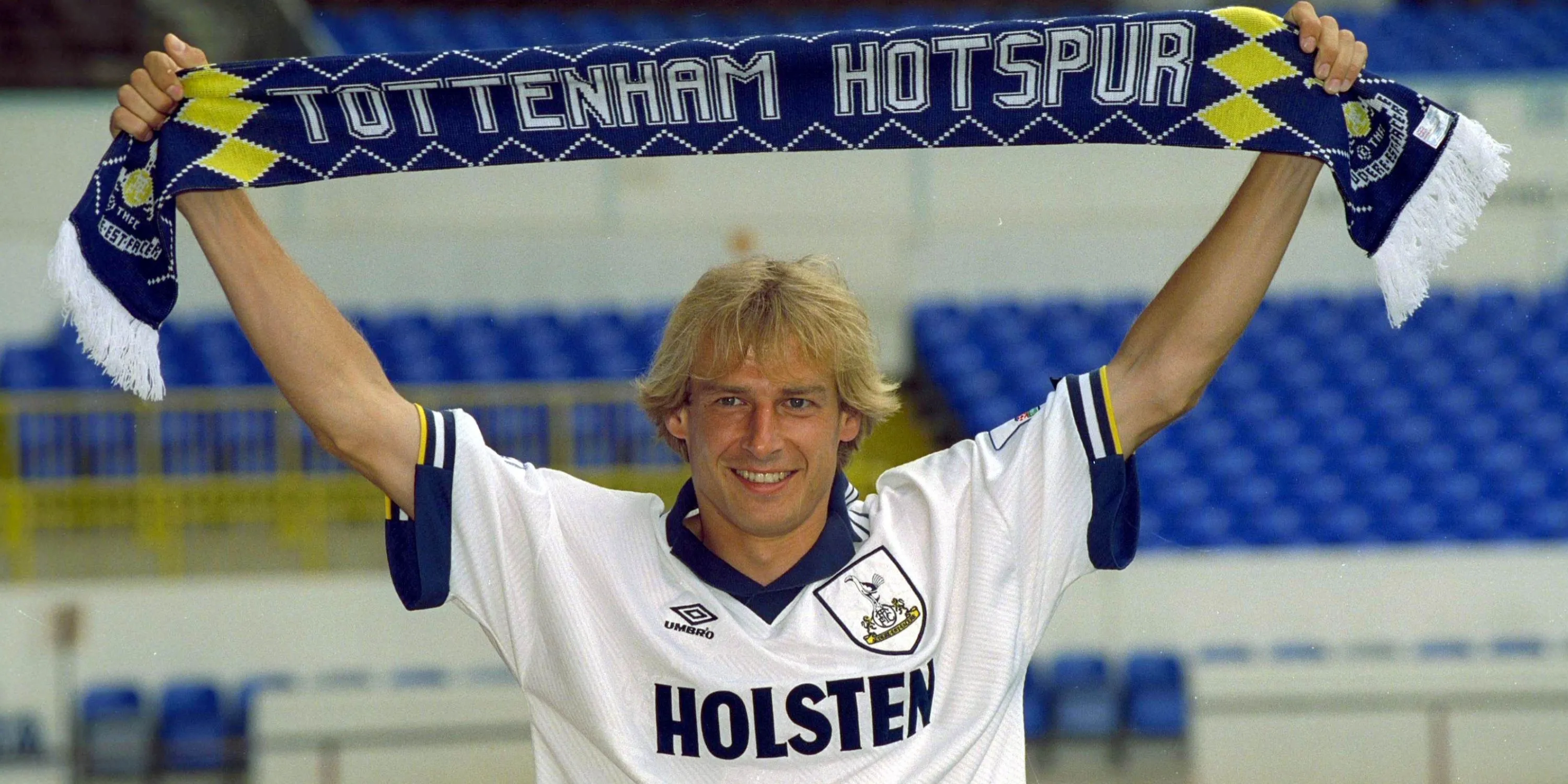 Jurgen Klinsmann tươi cười cầm khăn của Tottenham Hotspur sau khi ký hợp đồng.